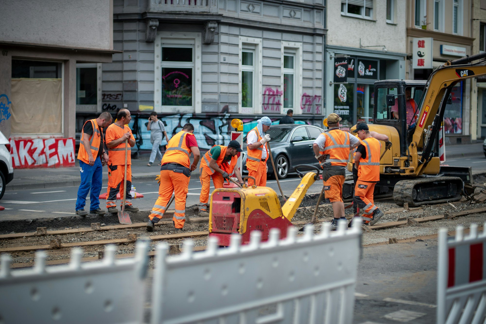 group of men in orange suit standing near building during daytime group of men in orange suit standing near building during daytime